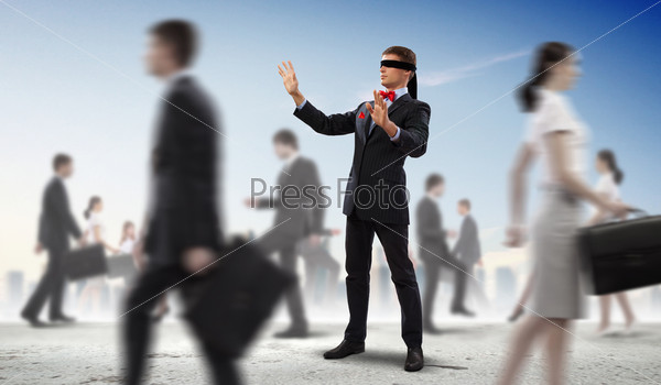 Image of businessman in blindfold walking among group of people, stock photo