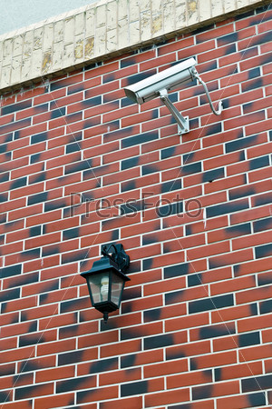 Security camera and flashlight on the wall of the house