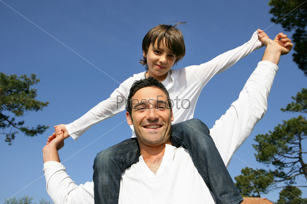 Man carrying his son on his shoulders, stock photo