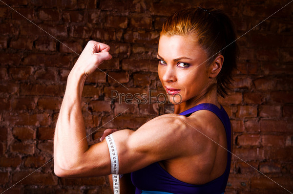 Strong Beautiful Woman Flexing Biceps Stock Photo, Picture and