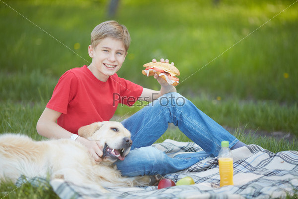 Portrait of cute lad and his fluffy friend having picnic