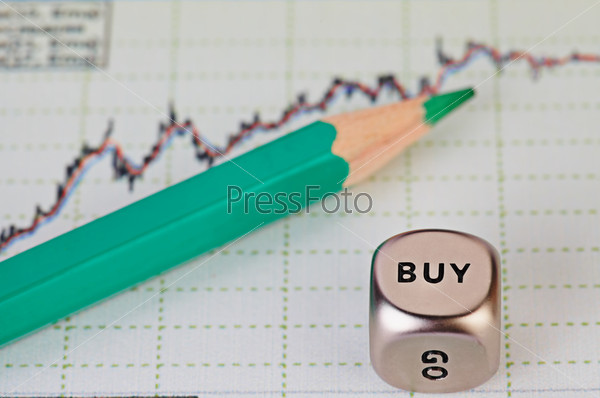Uptrend financial chart of the stock market,  green pencil and dices cube with the word BUY. Selective focus