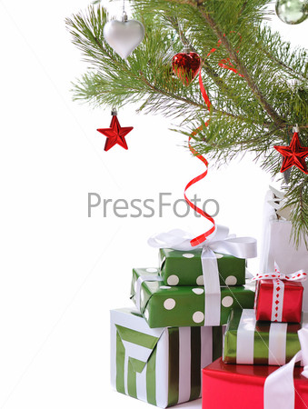 heap of gift boxes ornated with satin bow under decorated Christmas tree