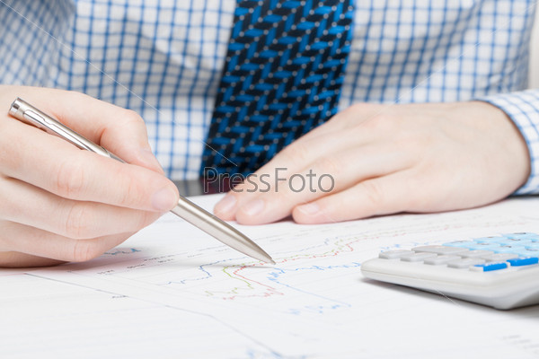 Business man doing calculations at the desk