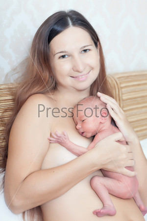 Mother holding a newborn baby skin-to-skin contact
