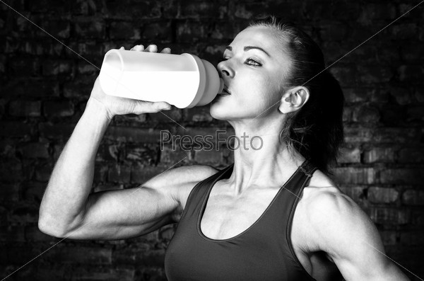 strong woman is drinking sports nutrition