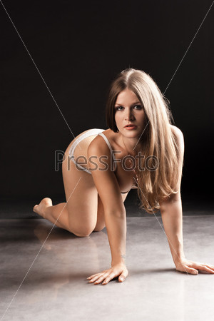 Sexy young woman posing on all fours