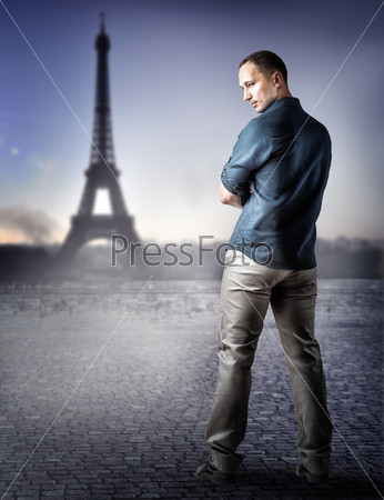 Young handsome casual man in fashion blue shirt and light gray trousers to Paris, France