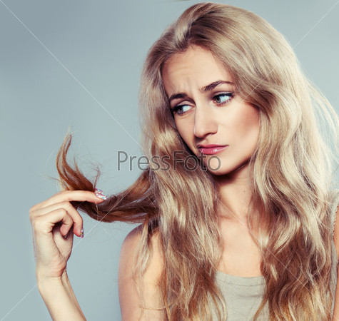 Young woman looking at split ends