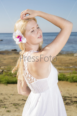 Youthful woman in dress with flower in hairs