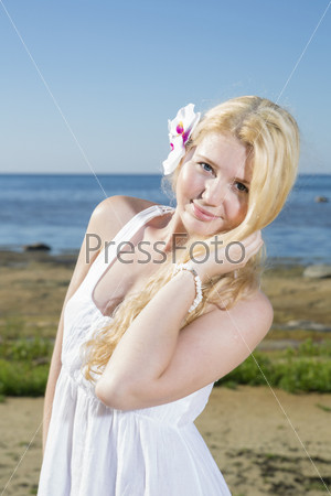 Blushing woman with white flower in hairs