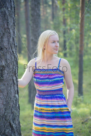 Woman in lined dress next to tree stem