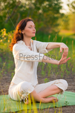 Stretching woman in outdoor exercise smiling happy doing yoga stretches. Beautiful happy smiling sport fitness model outside on summer / spring day