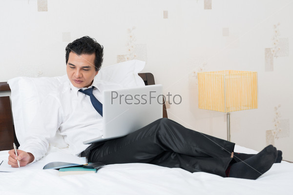 Portrait of a lying businessman working with computer