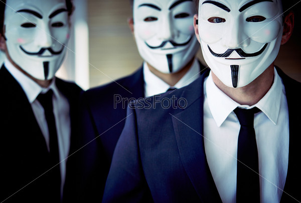 Close-up portrait of unrecognizable people wearing Guy Fawkes\
masks and business suits\
