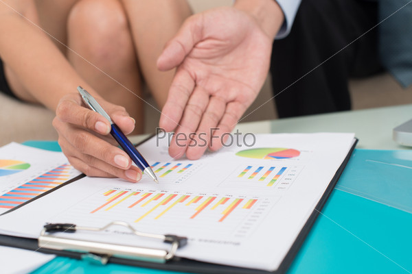 Business people analyzing financial statistics as a part of the annual report