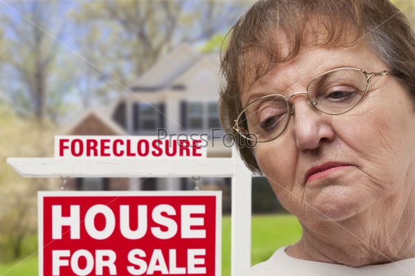 Depressed Senior Woman in Front of Foreclosure Real Estate Sign and House.