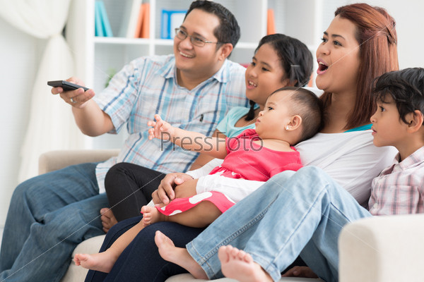 Image Of A Modern Family Watching Tv At Home