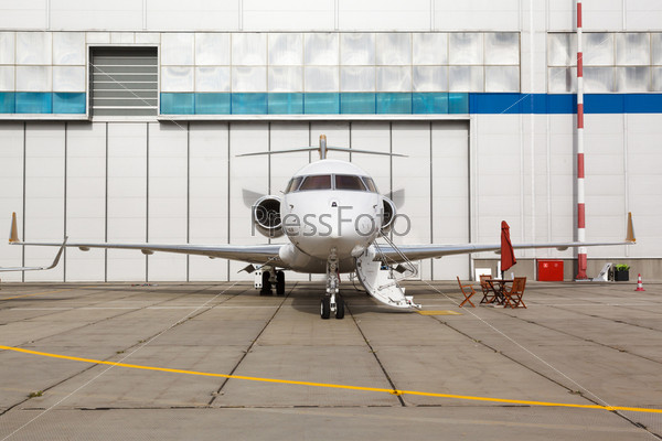 White reactive private jet, the front landing gear and a ladder