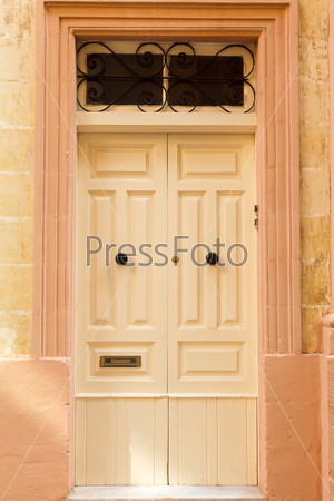 Light  wooden front door to the house in the Mediterranean