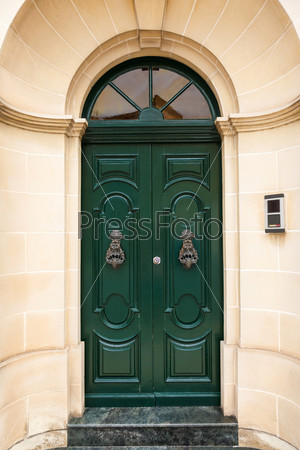 green wooden front door to the house in the Mediterranean