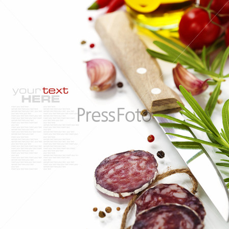 Close-up traditional sliced meat sausage salami with knife and vegetables