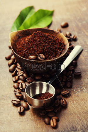 Wooden Bowl with ground coffee on wooden table