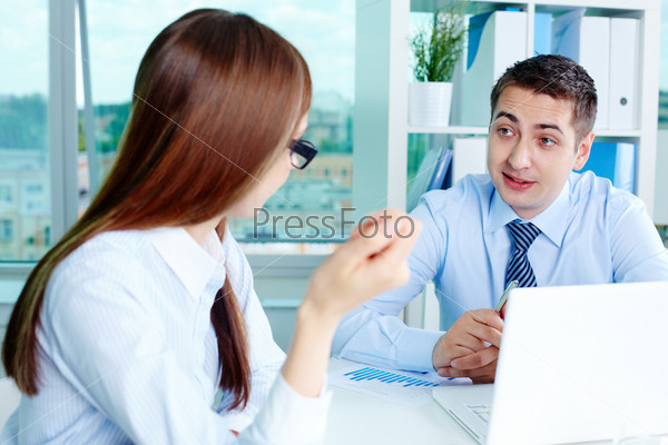 Image of two white collar workers during discussion of business ideas at meeting