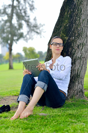 Beautiful young student woman study with tablet in park, stock photo