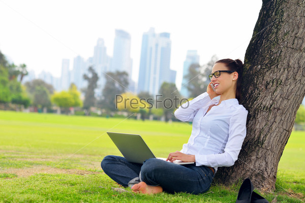 Happy young student woman with laptop in city park study, stock photo