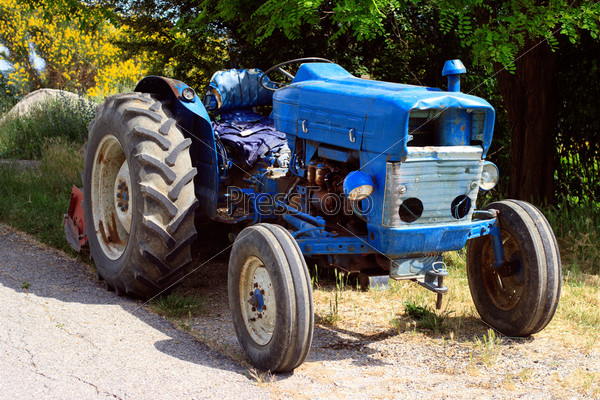 Old blue tractor on the road in Provence (France), stock photo