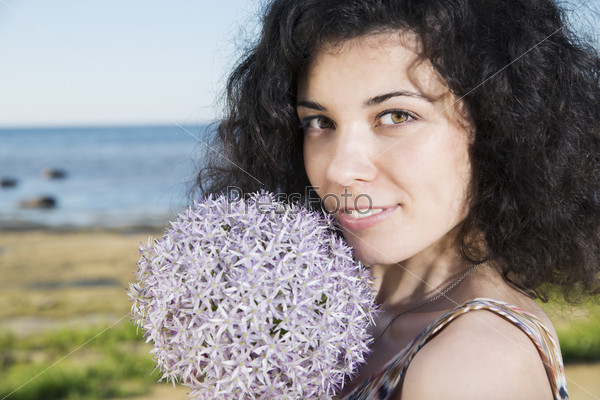 Zoomed young woman with dark hairs with flower