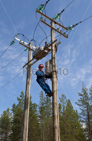Electrician perform maintenance on the transmission towers recloser  with the use of claws- manholes and  belt