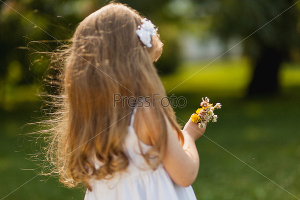 Girl with sunflower in summer field