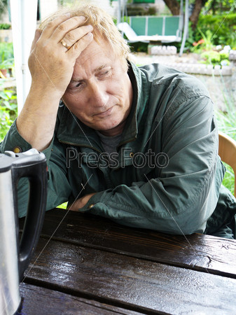 Closeup of an elderly man lost in thought , loneliness