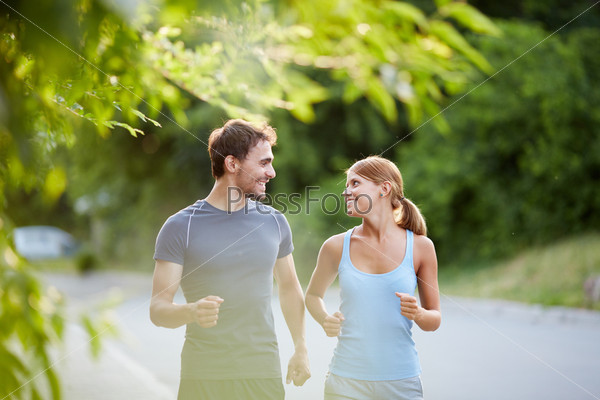 Photo of happy couple running outdoors