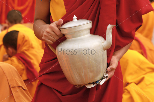 Tibetan tea teapot in the hands of a monk in Nepal