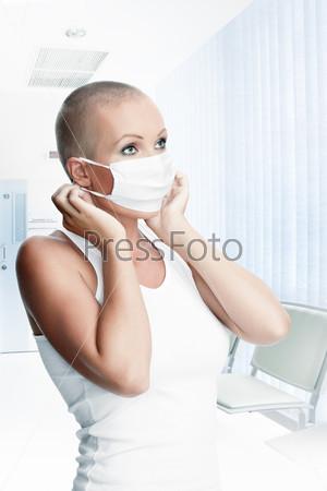Portrait of nice young woman in surgery mask on white back