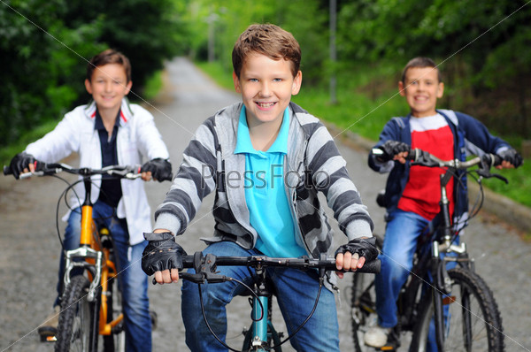 Portrait of three little cyclists riding their bikes
