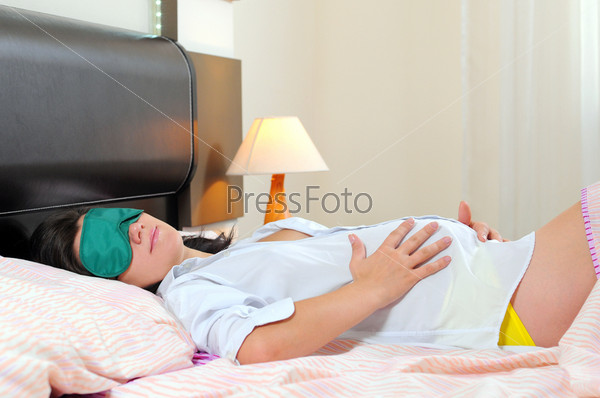 Photo of beautiful pregnant woman sleeping in bed