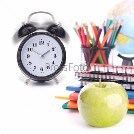 Alarm clock, notebook stack and pencils. Schoolchild and student studies accessories. Back to school concept.