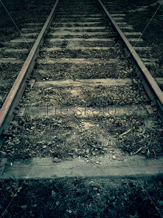 Old forgotten railroad in the dark, vintage background.
