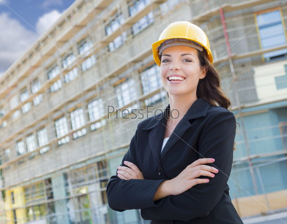 Portrait of Young Attractive Professional Female Contractor Wearing Hard Hat at Construction Site, stock photo