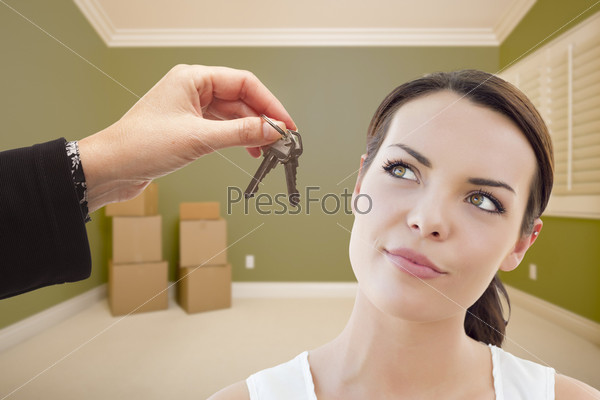 Young Woman Being Handed Keys in Empty Room with Boxes
