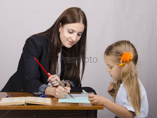 teacher teaches lessons with student sitting at table
