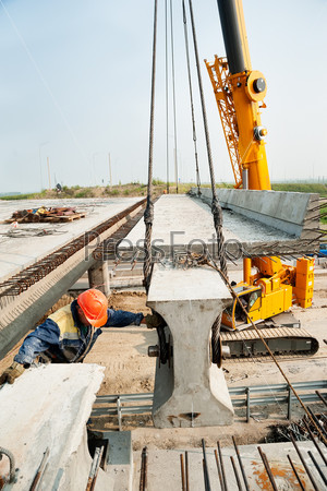 Tyumen, Russia - July 31, 2013: JSC Mostostroy-11. Bridge construction for outcome of the Tobolsk path and Bypass road round Tyumen. Workers mount bridge span