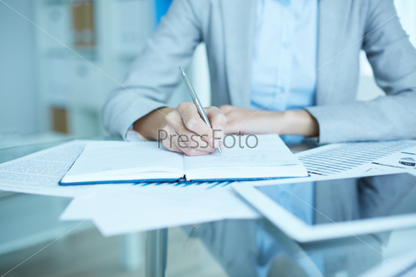 Office worker making notes in her notebook
