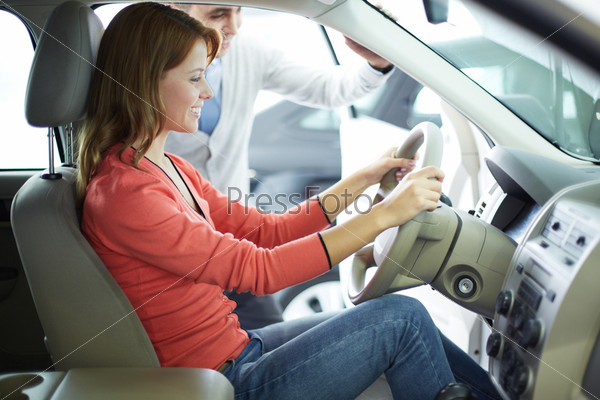 Smiling young woman being glad about her newly-bought car