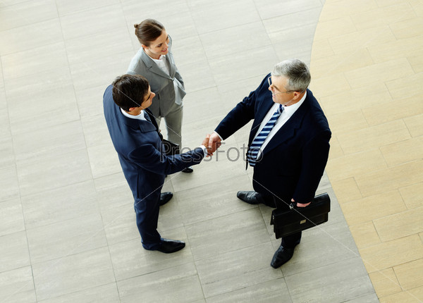 Two businessmen shaking hands indicating successfully made deal