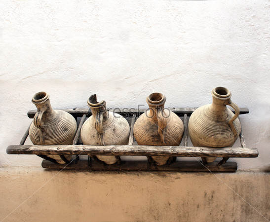 Ancient pitchers on stucco wall